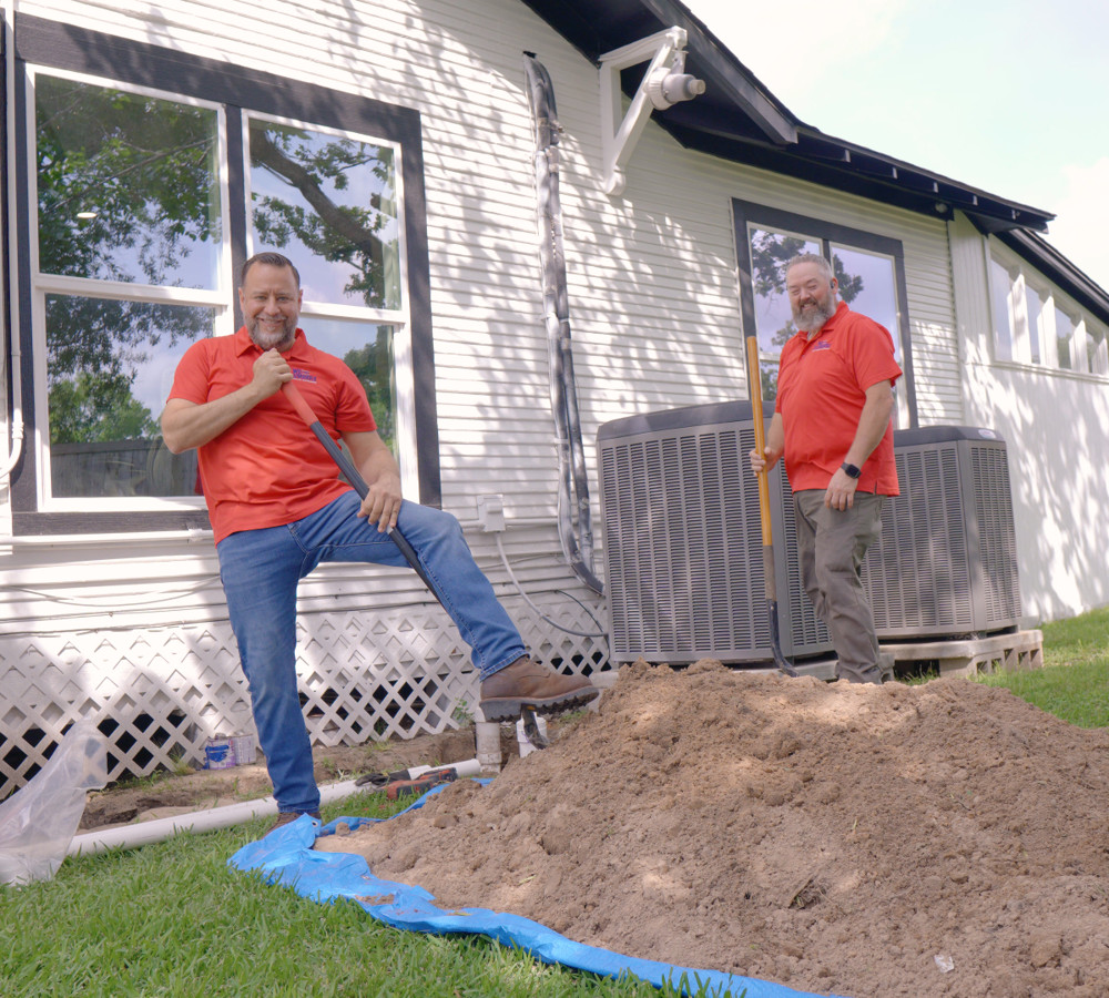 Plumbers at work on a backyard sewer excavation