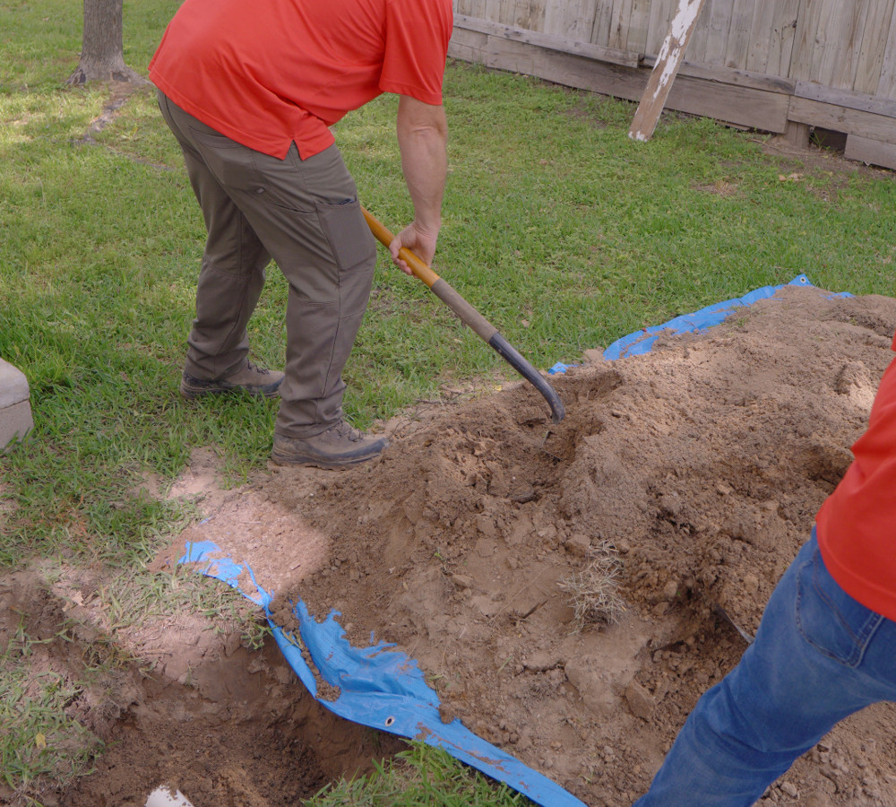 Close-up of a shovel moving soil at a sewer excavation