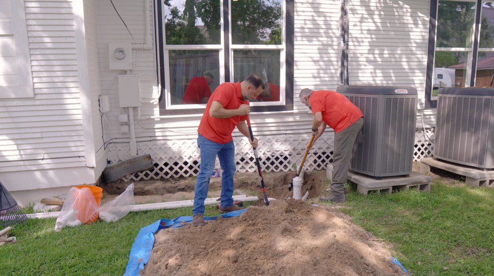 Plumbers working at a backyard sewer line repair