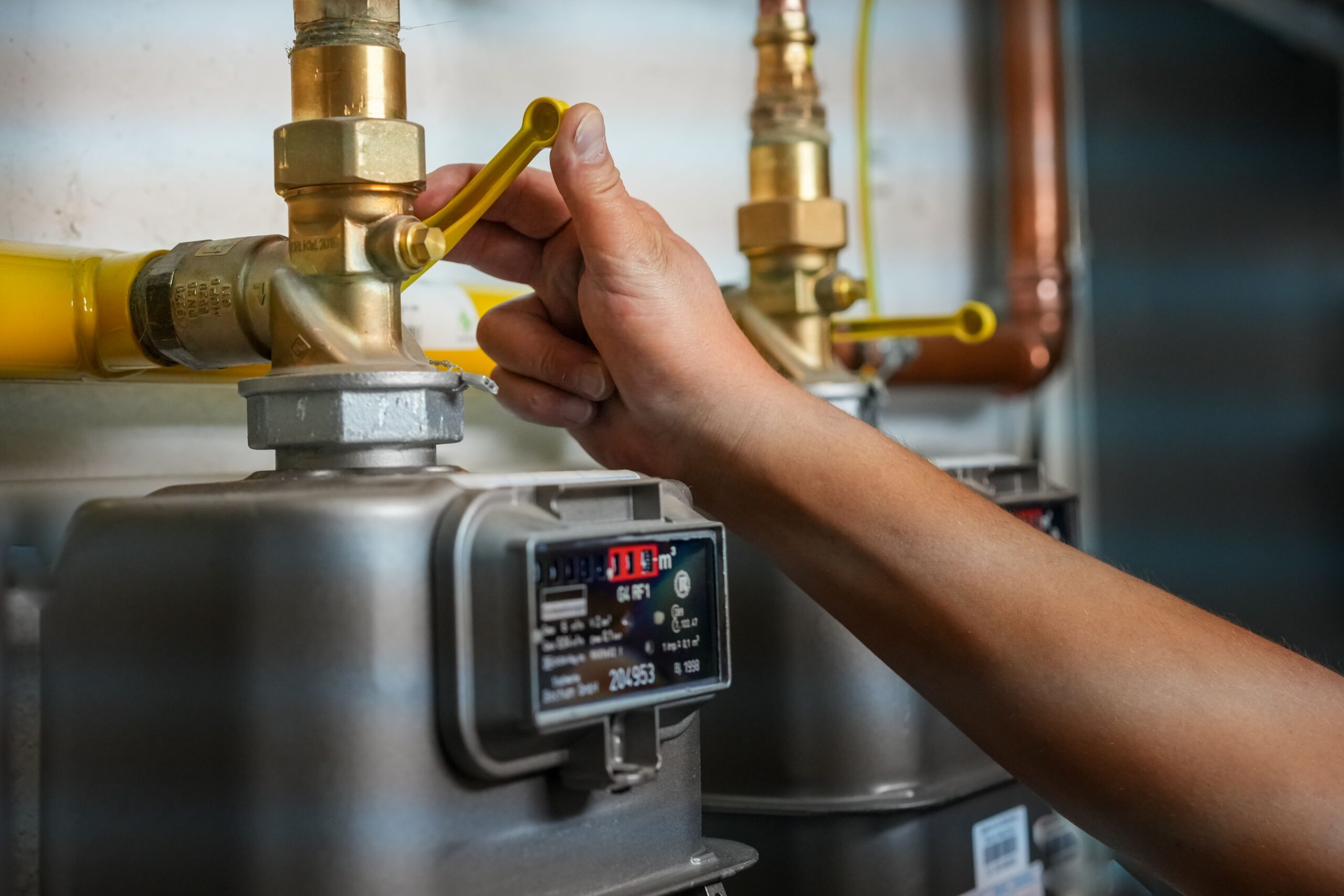 Technician adjusting a yellow-handled valve on a residential gas line during inspection and repair to ensure safe and code-compliant gas service in Conroe, Texas.